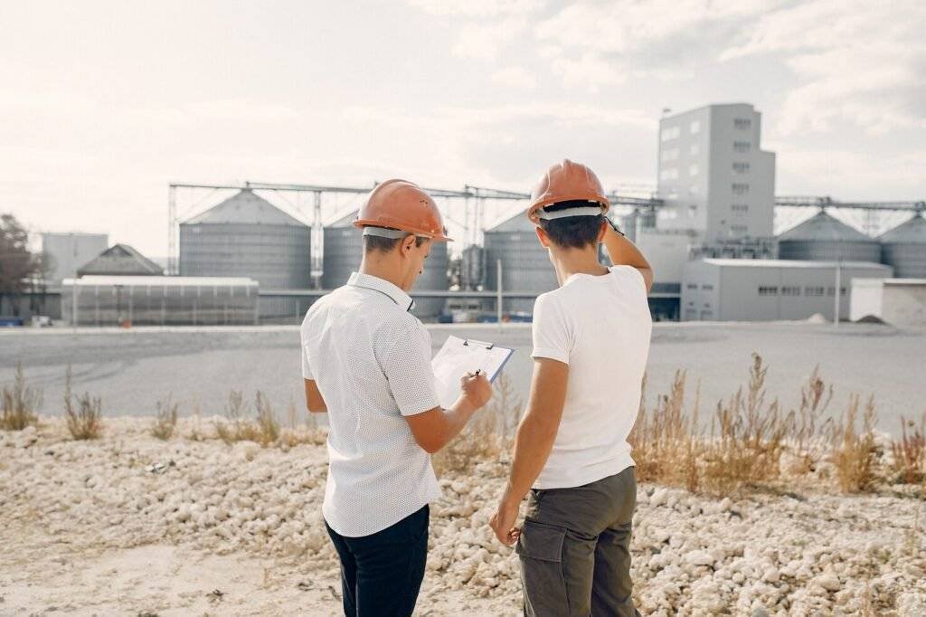engineers-helmets-standing-by-factory_1157-35333