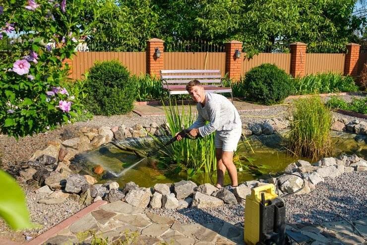 man-cleans-garden-pond-bottom-with-highpressure-washer-from-mud-sludge_85601-1131