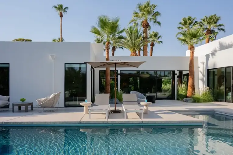 Pool and cabana framed by palm trees