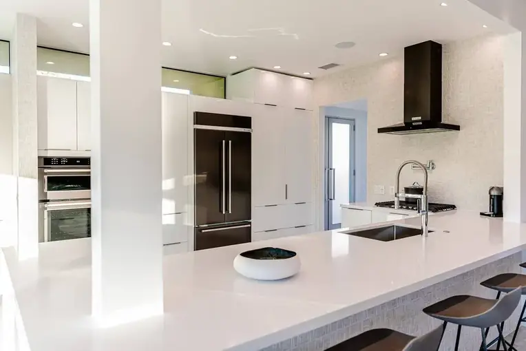 Bright white kitchen with a waterfall island