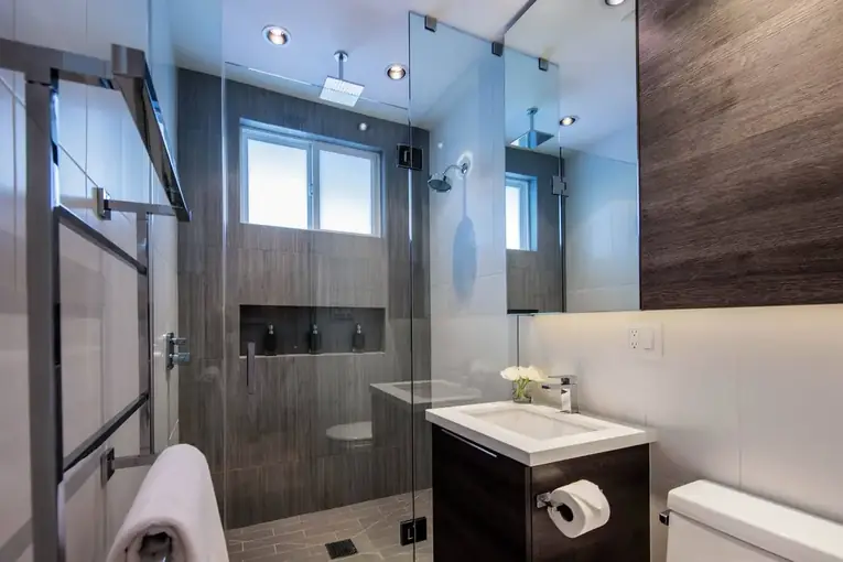 Bathroom with a glass shower and dark wood vanity